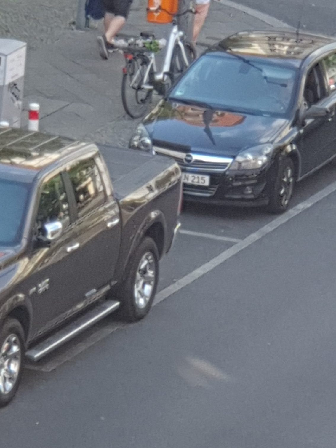 Ein Pickup-Van und ein Opel Astra parken verboten an einer Ladestation für Elektroautos in Berlin